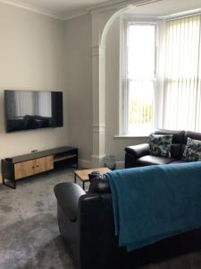 a living room with two couches and a flat screen tv at Jeffersons Abbey Road Serviced Apartments in Barrow in Furness