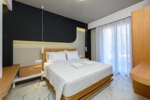 a bedroom with a large bed and a large window at Olea Luxury Villa in Skala Rachoniou