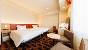 a hotel room with a bed and a table and chairs at JR-East Hotel Mets Koenji in Tokyo