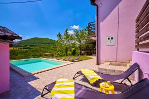 a purple house with a swimming pool and two chairs at Kuća za odmor s bazenom TeriHy in Klake