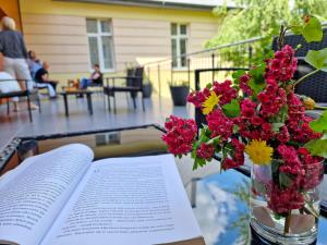 an open book on a table with a vase of flowers at Kompleks Hotelowo-Rekreacyjny “Kasztelanka” in Ciechocinek