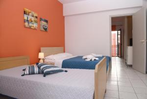イラクリオン・タウンにあるEconomic Studios in Creteのオレンジ色の壁の客室内のベッド2台