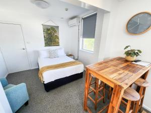 a bedroom with a bed and a desk and a clock at The Stella in Yamba