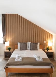 sypialnia z dużym łóżkiem z ręcznikami w obiekcie Zona Optimizma accommodation & SPA w mieście Vršac