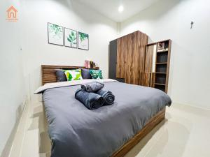 a bedroom with a large bed with blue pillows on it at Baan lang lek บ้านหลังเล็ก in Ban Tha Kup