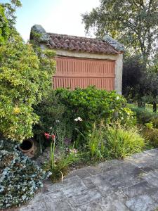 un garage rosso con molte piante e fiori di Villa Ponte Bora a Pontevedra