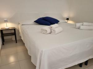 una camera da letto con un letto bianco e asciugamani di Casa Sofia a Vulcano