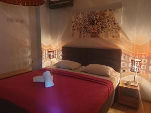 Un dormitorio con una cama roja con un objeto blanco. en Hostel Museum en Koper