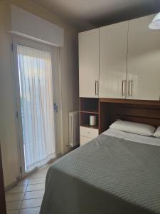 um quarto com uma cama e uma grande janela em Marconi House em Alba Adriatica