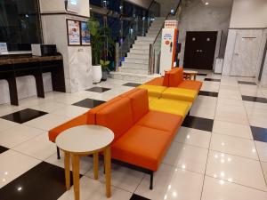 Toyoko Inn Busan Station No.1 في بوسان: لوبي وكراسي برتقالية وصفراء وطاولة