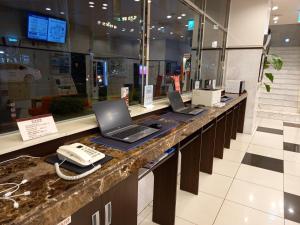 a counter with two laptops and a phone on it at Toyoko Inn Busan Station No.1 in Busan