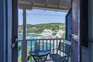 einen Balkon mit einem Tisch und Stühlen sowie Meerblick in der Unterkunft Levantes Hotel in Patitiri