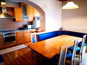 a kitchen with a wooden table and blue chairs at Apartment Sončni Mokec in Rečica ob Savinji