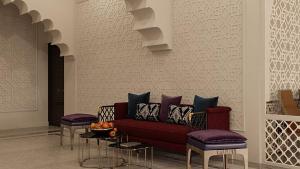 a living room with a red couch and two stools at Reikartz Sote Tashkent in Tashkent