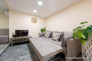 a living room with a couch and a tv at Κτήμα Mairy΄s House in Flogita