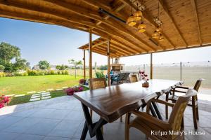 a wooden table and chairs on a patio at Κτήμα Mairy΄s House in Flogita