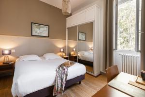 una camera con letto, scrivania e specchio di Villa Sainte Anne a Porquerolles