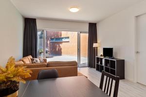 een woonkamer met een bank en een tafel bij Hertog 2 Modern and perfectly located apartment in Eindhoven
