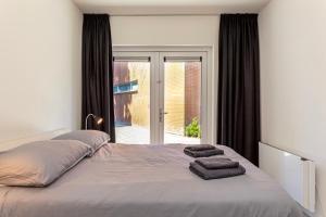 een slaapkamer met een bed met twee handdoeken erop bij Hertog 2 Modern and perfectly located apartment in Eindhoven