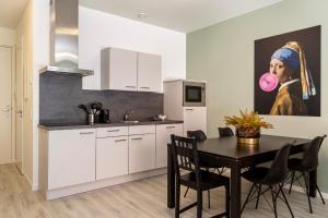 a kitchen with a table and a painting of a woman at Hertog 2 Modern and perfectly located apartment in Eindhoven