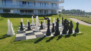 un tablero de ajedrez está sentado en el césped frente a un edificio en Apartament Perła Bałtyku Polanki Aqua z parkingiem. en Kołobrzeg