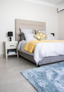 a bedroom with a bed and a blue rug at Asania Guest House in Bloemfontein