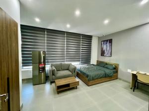 ein Schlafzimmer mit einem Bett, einem Stuhl und einem Kühlschrank in der Unterkunft Căn hộ view Hoàng Hôn chuỗi Space Apartment & HomeStay tại Vinhomes Marina Hải Phòng in Xóm Niêm