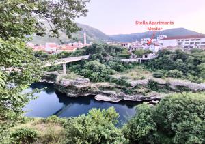 莫斯塔爾的住宿－Stella Apartments Mostar，享有一座城市的美景,设有一座河流上的桥梁