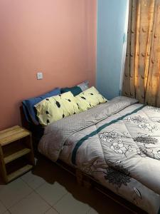 Una cama pequeña en una habitación con ventana. en Impeccable homely 1-Bed Apartment in Nairobi, en Nairobi