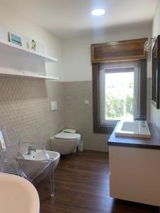 La salle de bains est pourvue d'un lavabo, de toilettes et d'une fenêtre. dans l'établissement Villa Maria Marchesana, à Pezzi di Gala