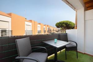 a table and chairs on the balcony of a building at Apartamento La Jara in Chiclana de la Frontera