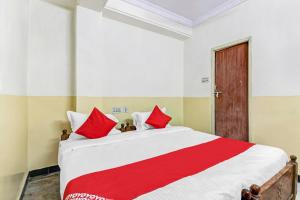 een slaapkamer met een groot bed met rode kussens bij OYO Suraj Residency in Warangal