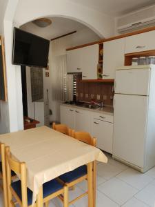a kitchen with a table and a white refrigerator at Apartment Tereza in Sutivan