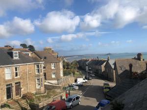 a view of a street in a town with cars parked at Modern Attic Studio Apartment with harbour views in Penzance