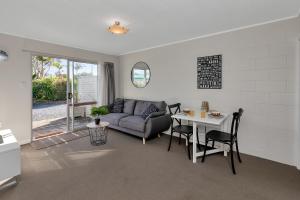 a living room with a couch and a table at Hidden Away - Tauranga Bay Holiday Unit in Mahinepua