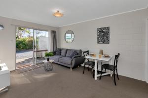 a living room with a couch and a table at Beach Daze - Tauranga Bay Holiday Unit in Mahinepua