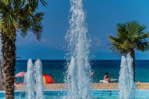 a fountain in front of the beach with palm trees at Flogita Dream in Flogita