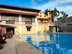 a swimming pool in front of a building at El Juliana Hotel in Vigan