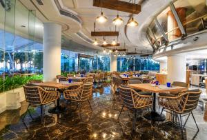 a restaurant with wooden tables and chairs and windows at Ocean Marina Resort Pattaya Jomtien in Na Jomtien