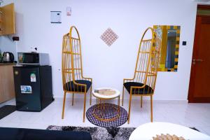 two chairs and a table in a living room at First class apartments in Kiambu