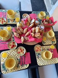 stół z talerzami, kubkami i jedzeniem w obiekcie Villa près des remparts w mieście Régusse