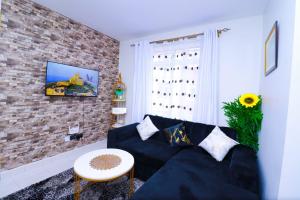 a living room with a black couch and a brick wall at First class apartments in Kiambu