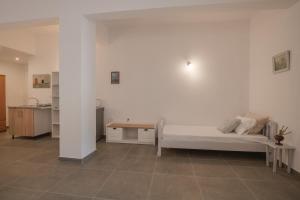 a white room with a bed and a table at Levantes Hotel in Patitiri