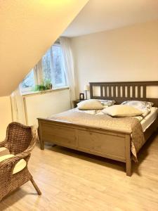 a bedroom with a bed and a chair and a window at Station L in Langballig