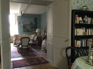 a living room with a book shelf with books at L’orangerie du Général in Saint-Jean-dʼAngély