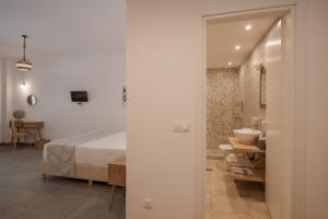 a bedroom with a bed and a bathroom with a sink at Levantes Hotel in Patitiri