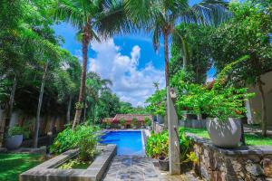 einen Pool in einem Garten mit Palmen in der Unterkunft Terrace Garden Ayurveda Resort in Weligama