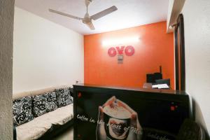 a living room with a couch and an orange wall at OYO Hotel Honey House in Mahabaleshwar