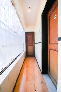 an empty hallway with a door and a wooden floor at OYO Hotel Honey House in Mahabaleshwar