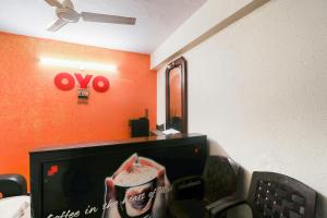 a living room with a tv and a mirror at OYO Hotel Honey House in Mahabaleshwar